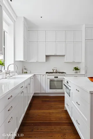 a kitchen with granite countertop white cabinets and white appliances