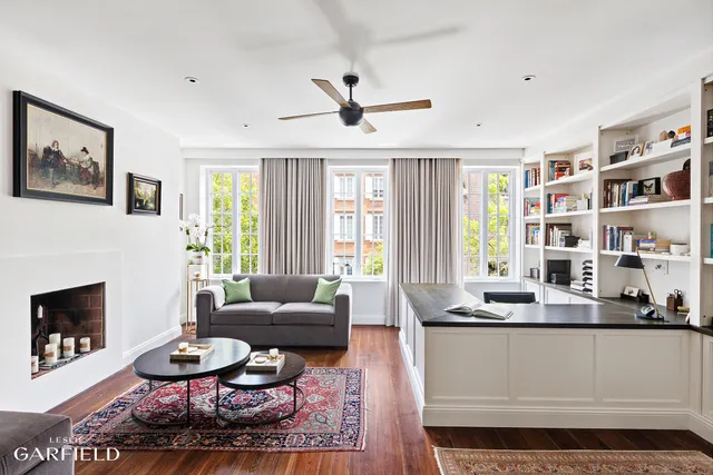 a living room with furniture a fireplace and a large window