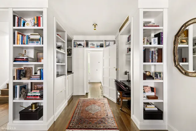 a living room with lots of books and a book shelf