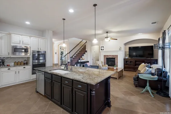 a large kitchen with kitchen island a island a stove a oven a dining table and chairs