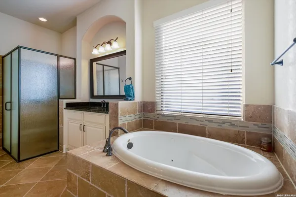 a bathroom with a bathtub sink and mirror
