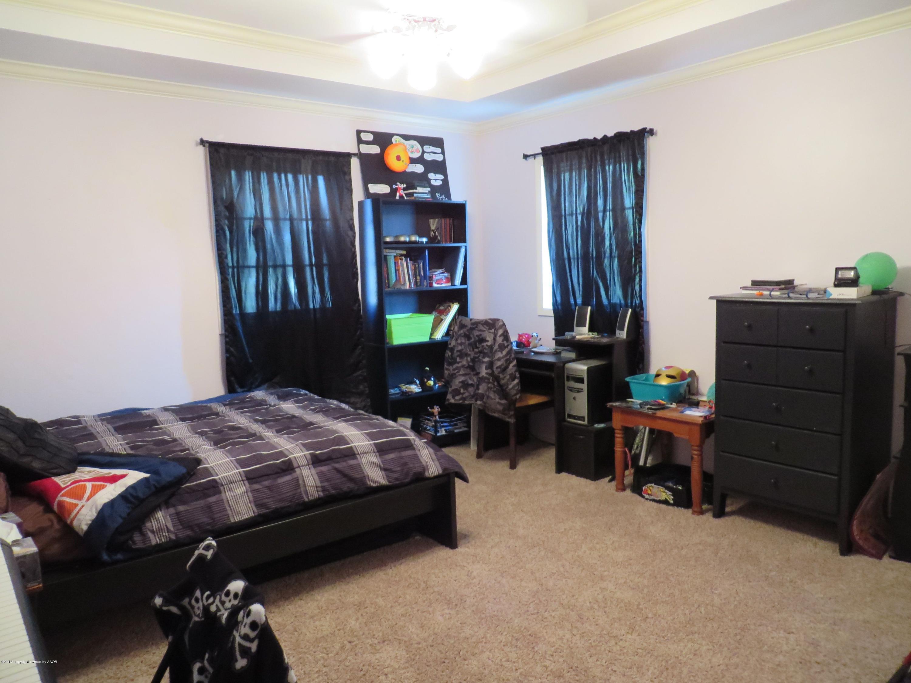 6713 Jameson Road Amarillo, TX 79106 - Photo 14 of 23 a bedroom with a bed and furniture
