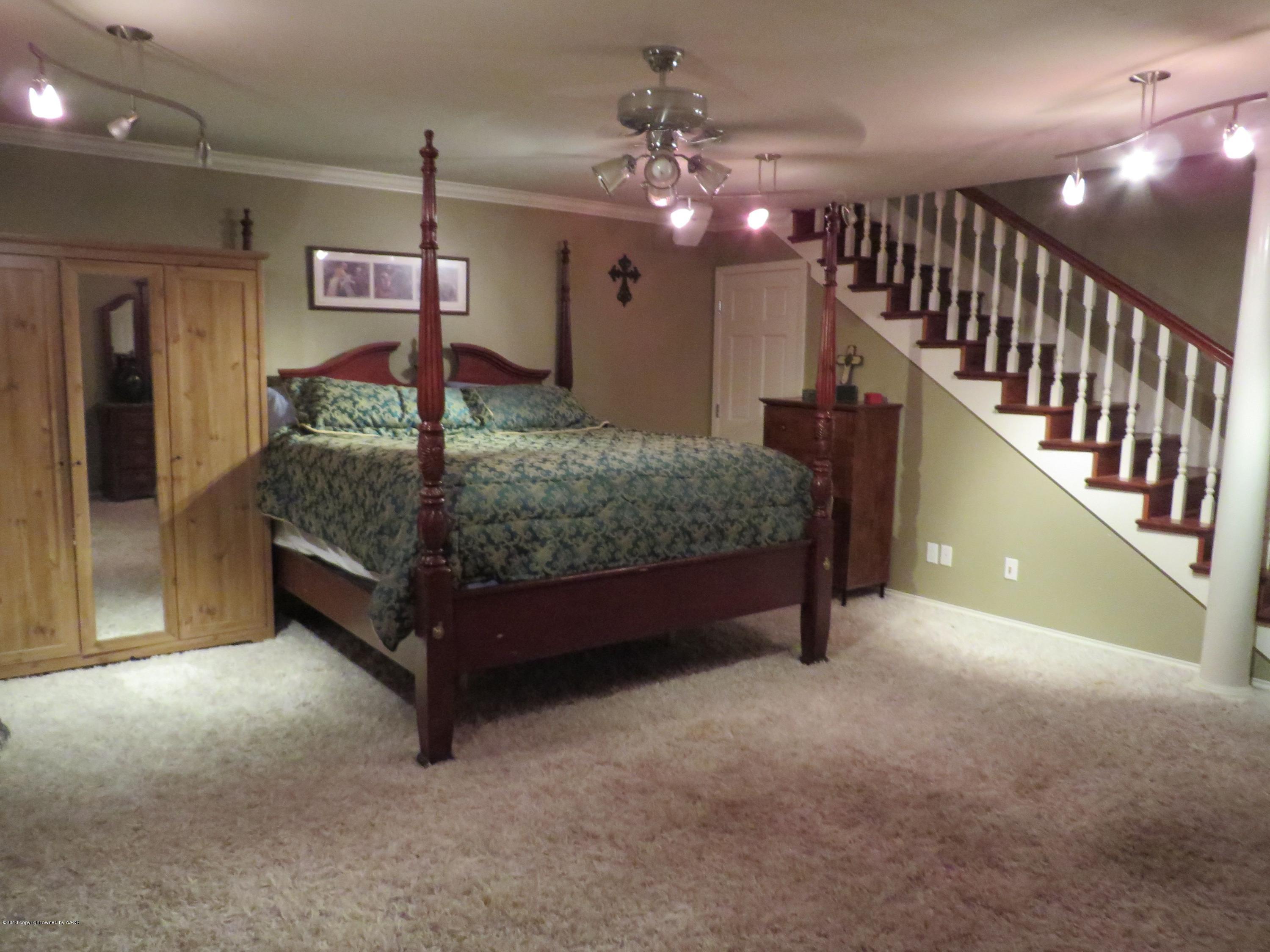 6713 Jameson Road Amarillo, TX 79106 - Photo 20 of 23 a bed room with a bed and a chandelier