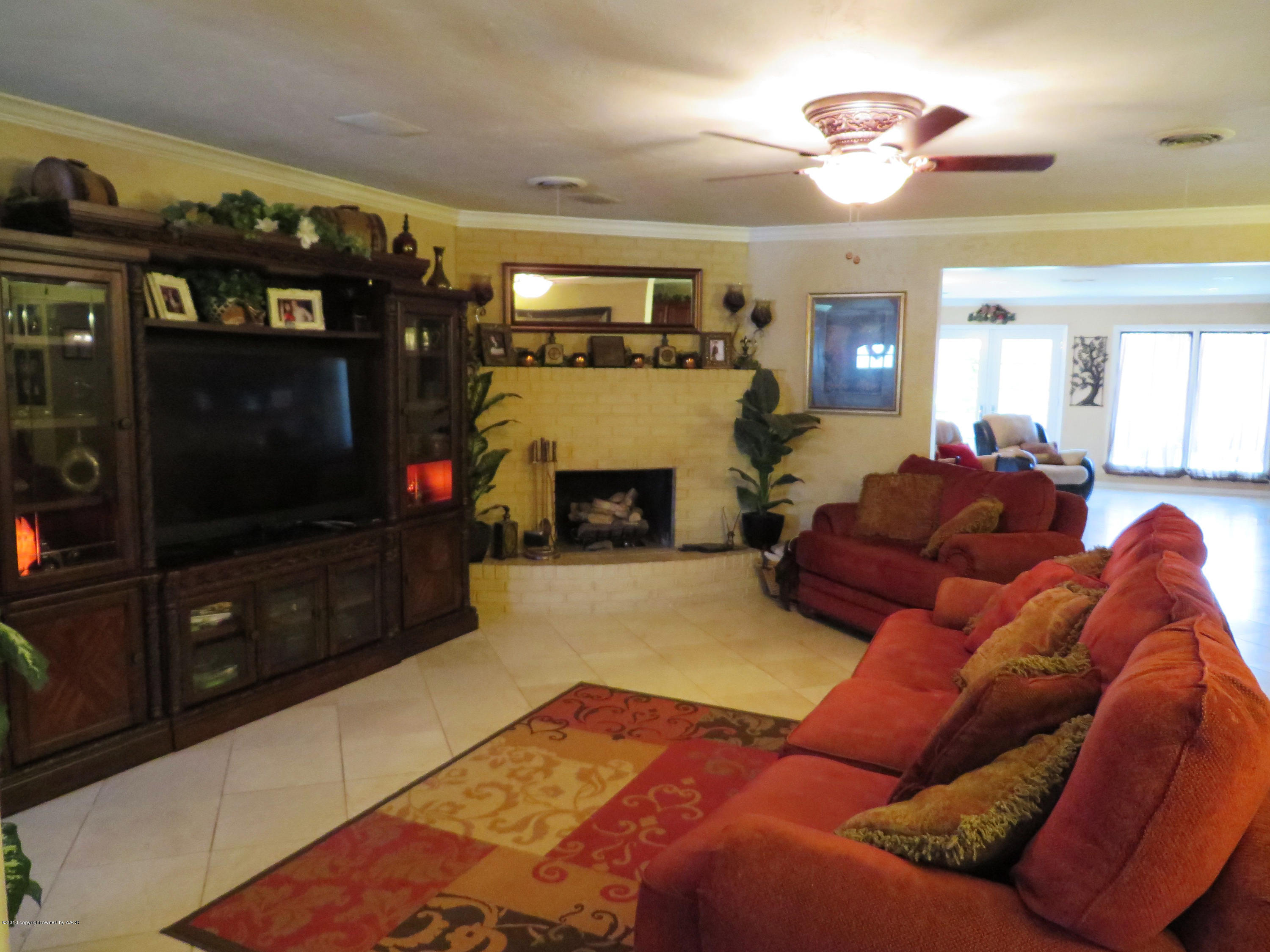 6713 Jameson Road Amarillo, TX 79106 - Photo 4 of 23 a living room with furniture a flat screen tv and a fireplace