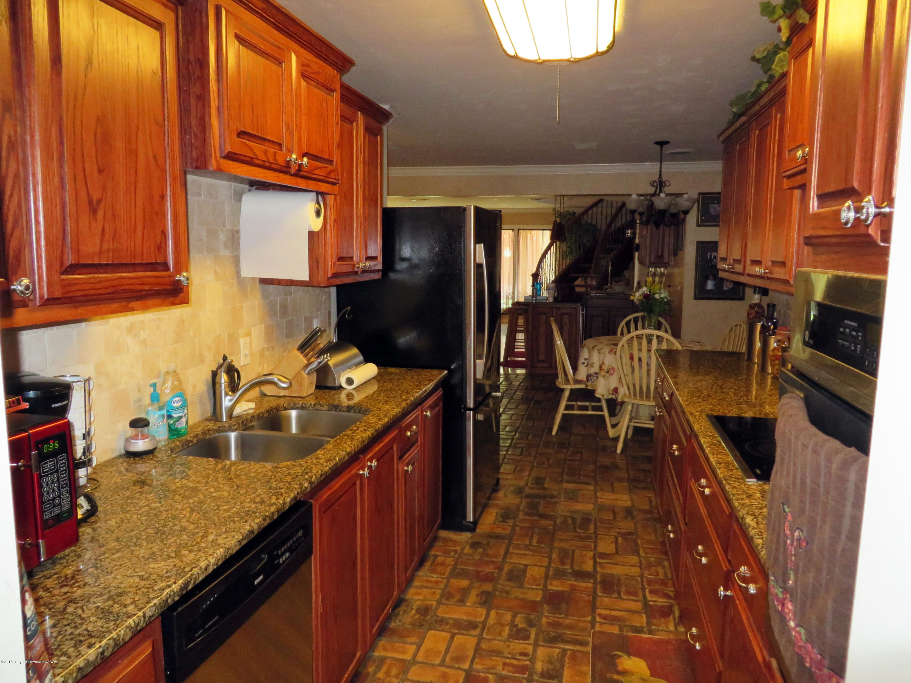 6713 Jameson Road Amarillo, TX 79106 - Photo 8 of 23 a kitchen with sink a refrigerator and cabinets