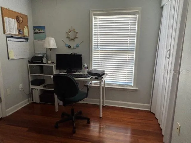 a view of a workspace with furniture and a window