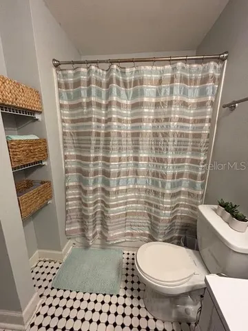 a bathroom with a toilet and a shower curtain