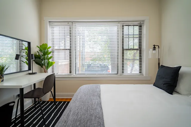 a bed sitting in a bedroom next to a window