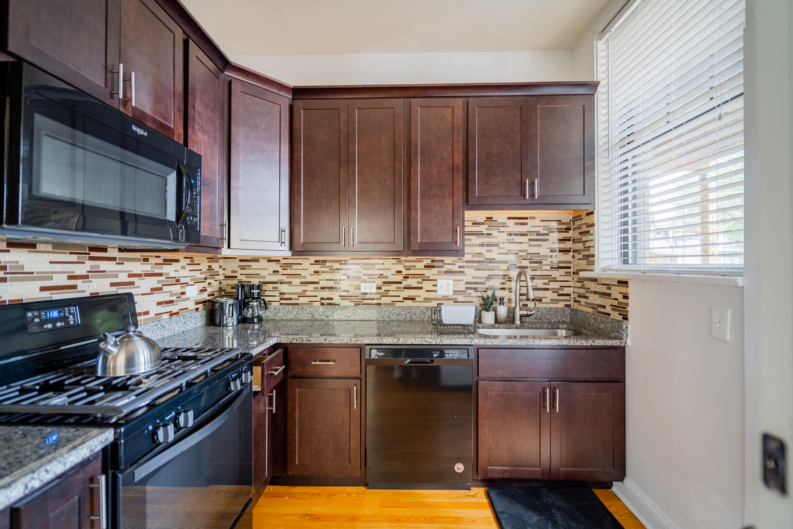 2989 North Lawndale Avenue, Unit 1 Chicago, IL 60618 - Photo 17 of 18 a kitchen with granite countertop stainless steel appliances and wooden cabinets