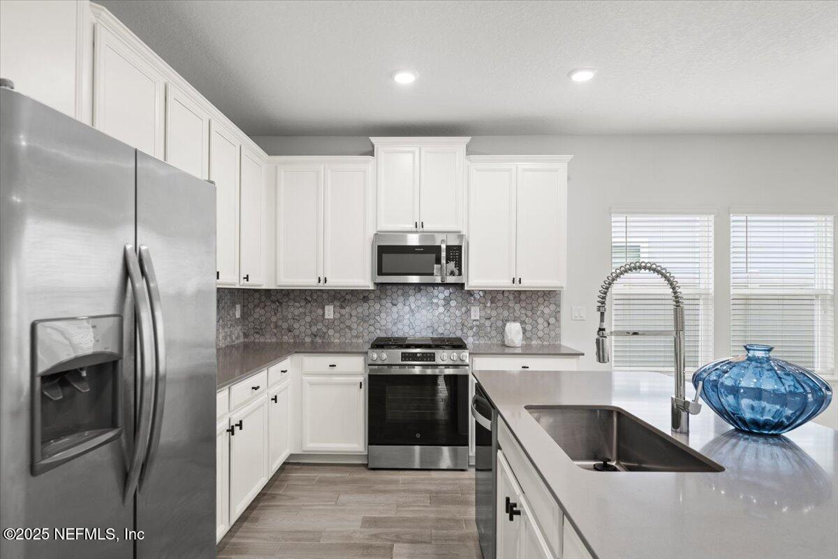 24 Purus Way St. Johns, FL 32259 - Photo 8 of 37 a kitchen with stainless steel appliances granite countertop a sink a stove and refrigerator