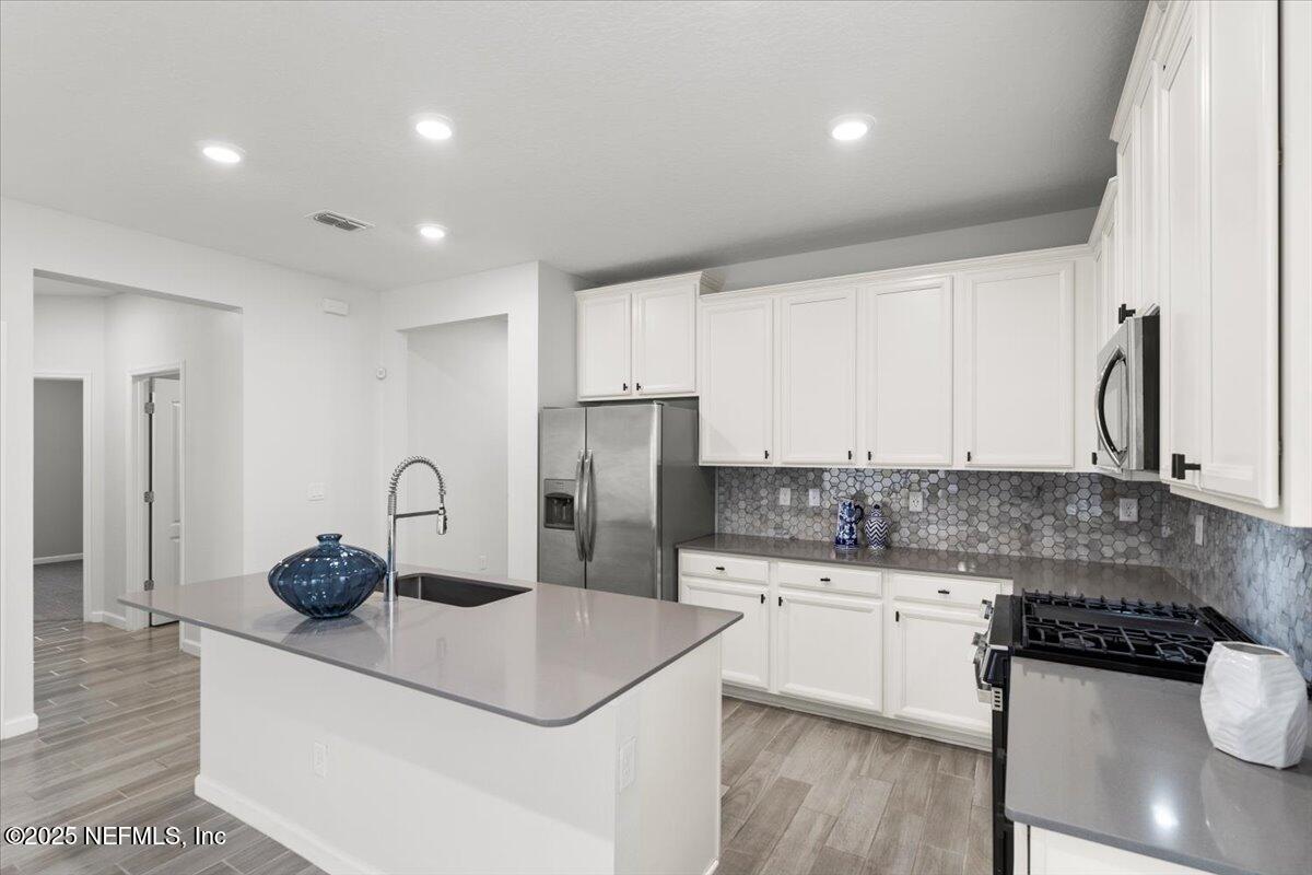 24 Purus Way St. Johns, FL 32259 - Photo 9 of 37 a kitchen with stainless steel appliances granite countertop a sink cabinets and wooden floor