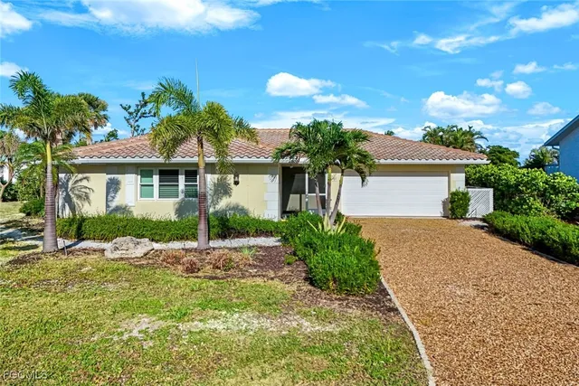 a front view of a house with a yard and potted plants