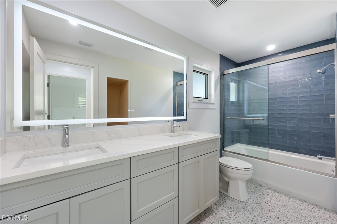 707 Durion Court Sanibel, FL 33957 - Photo 19 of 31 a bathroom with a double vanity sink toilet mirror and bathtub
