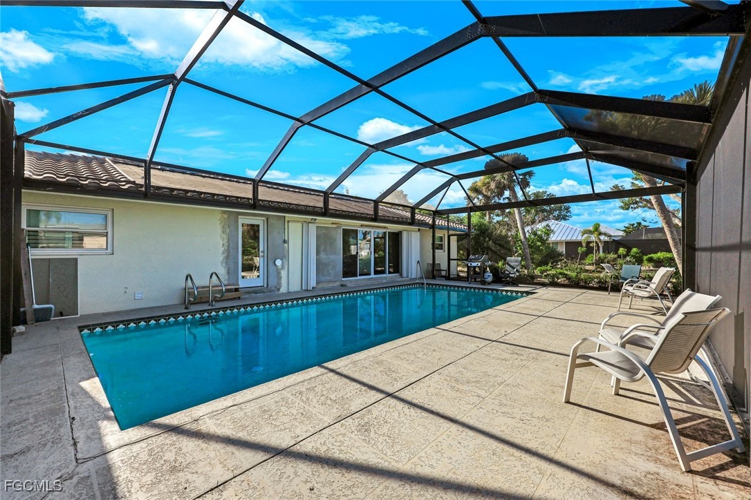 707 Durion Court Sanibel, FL 33957 - Photo 23 of 31 a view of a backyard with table and chairs under an umbrella