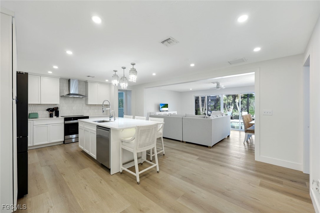 707 Durion Court Sanibel, FL 33957 - Photo 10 of 31 a kitchen with a dining table chairs refrigerator and cabinets