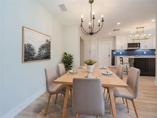 a view of a dining room with furniture a chandelier and wooden floor
