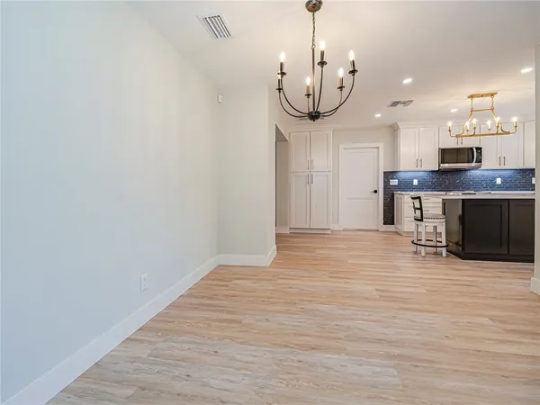 a view of a room with wooden floor and stainless steel appliances