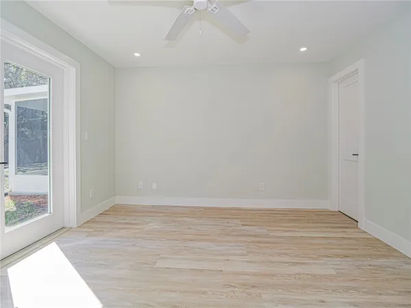 a view of an empty room with wooden floor and a window