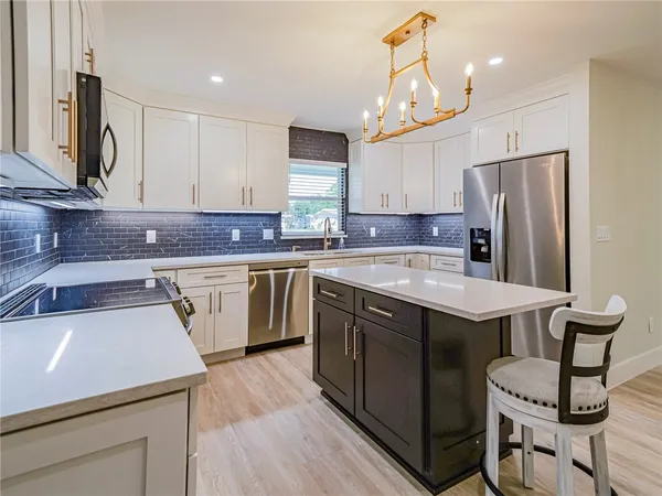a kitchen with stainless steel appliances a sink stove and refrigerator