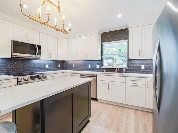 a kitchen with stainless steel appliances granite countertop a sink a stove a microwave and cabinets