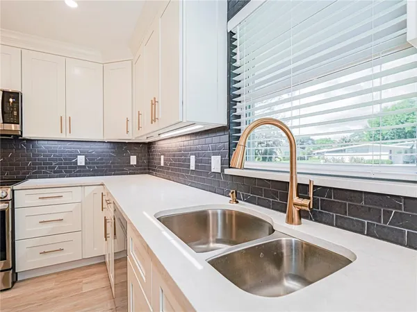 a kitchen with sink a window and cabinets