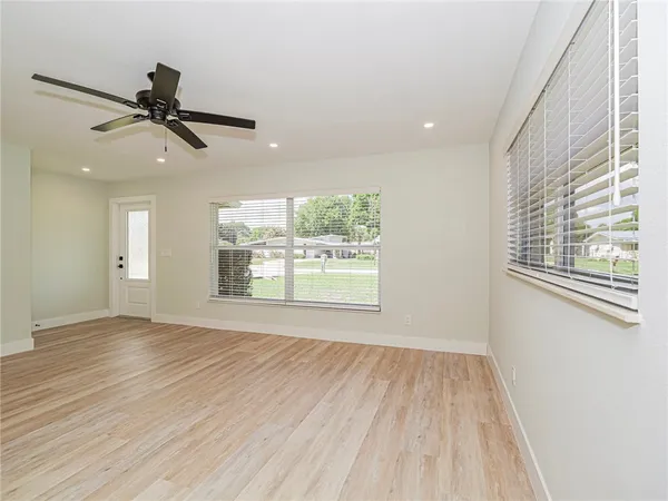 a view of an empty room with a window and wooden floor