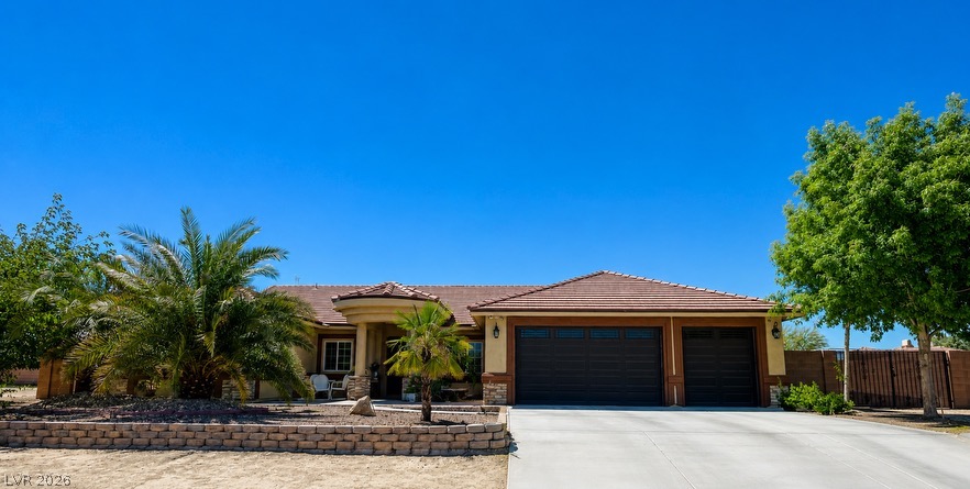 6720 Stubblefield Drive Pahrump, NV 89061 - Photo 2 of 3 A well-maintained facade with a prominent driveway, mature landscaping, and a welcoming front entrance.
