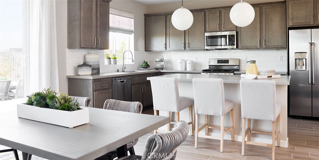 11541 Jack Street Beaumont, CA 92223 - Photo 7 of 11 a kitchen with stainless steel appliances a table chairs and a refrigerator