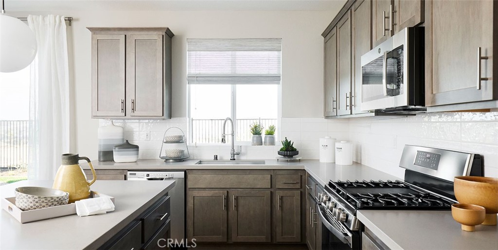 11541 Jack Street Beaumont, CA 92223 - Photo 8 of 11 a kitchen with stainless steel appliances granite countertop a sink stove refrigerator and cabinets