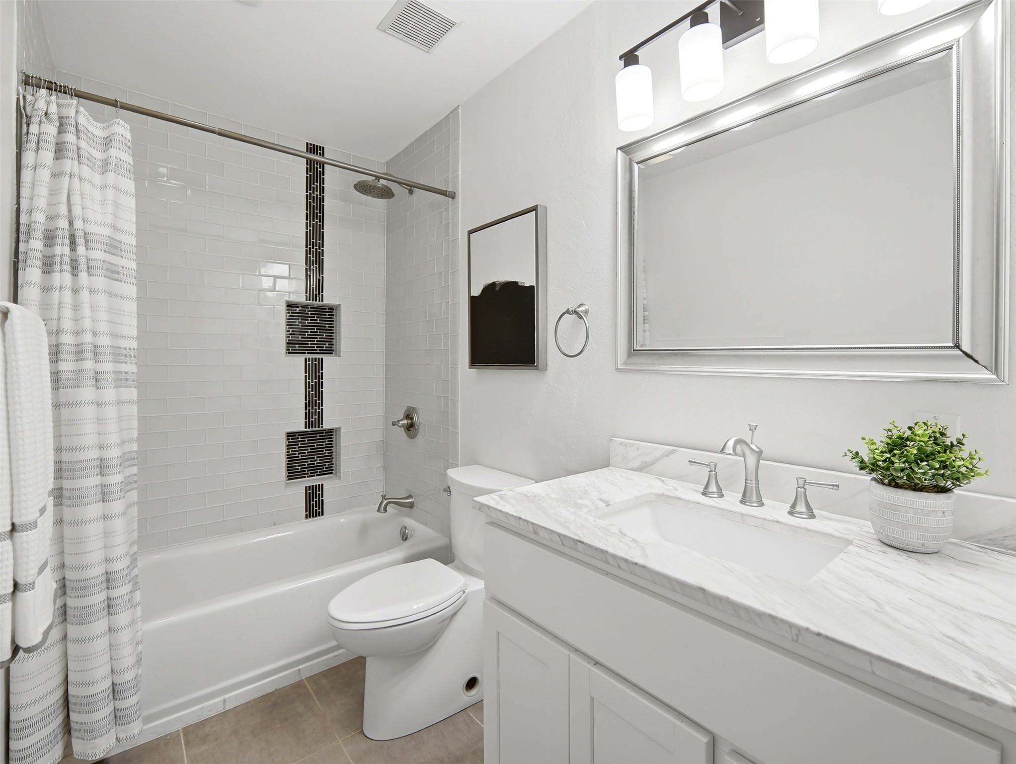 7001 Windrift Way Austin, TX 78745 - Photo 12 of 17 A well-appointed bathroom with a marble-topped vanity and modern tile work.