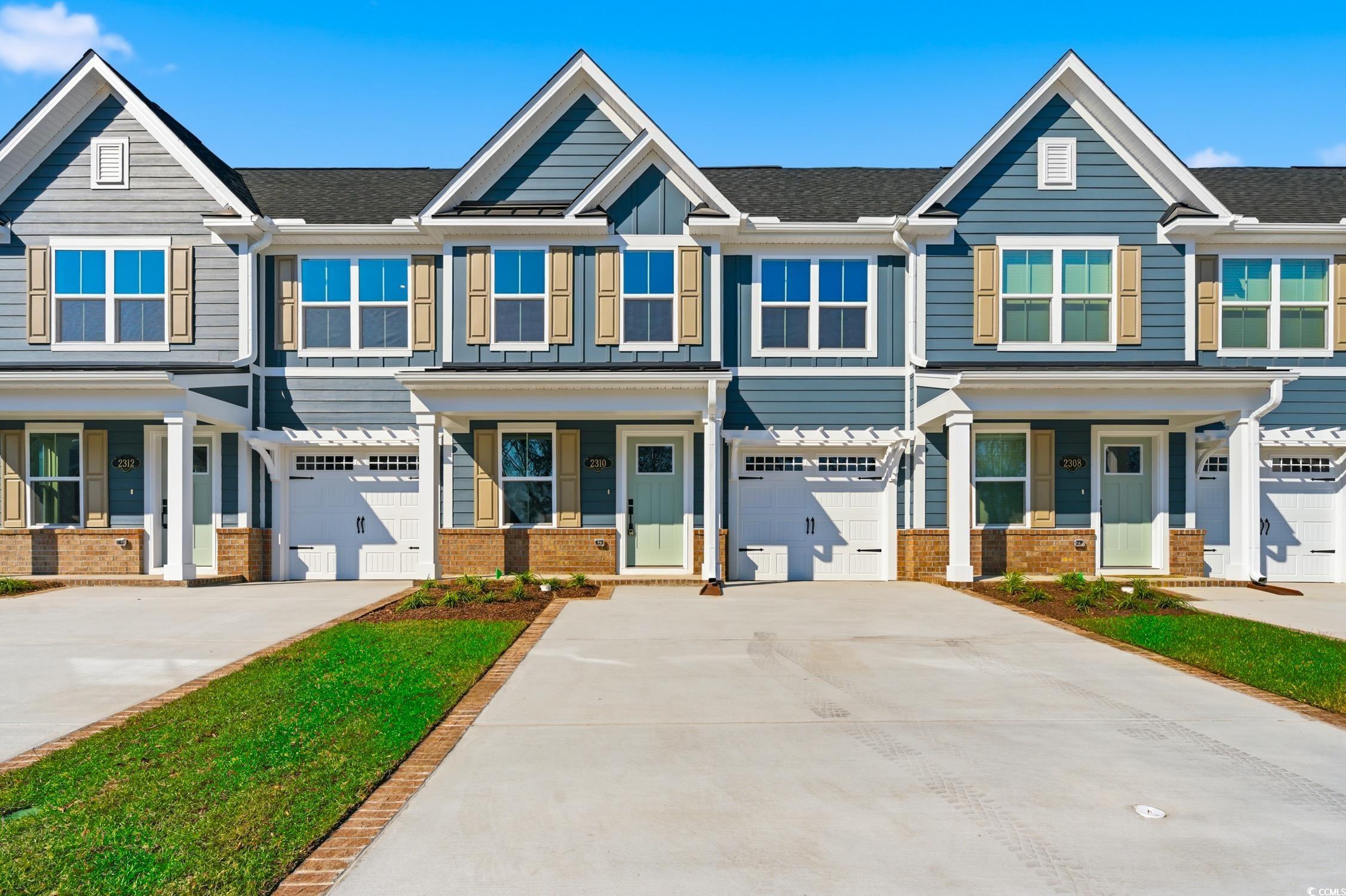 Craftsman inspired home featuring brick siding, driveway, and an attached garage