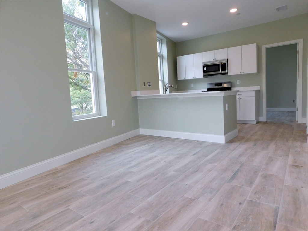 10 Roxbury Street, Unit 8 Boston, MA 02119 - Photo 9 of 10 a view of kitchen with wooden floor and electronic appliances