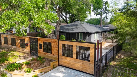 a view of a house with a small yard plants and large tree