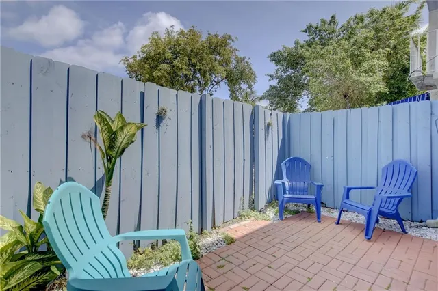 a view of a chairs in patio with wooden fence