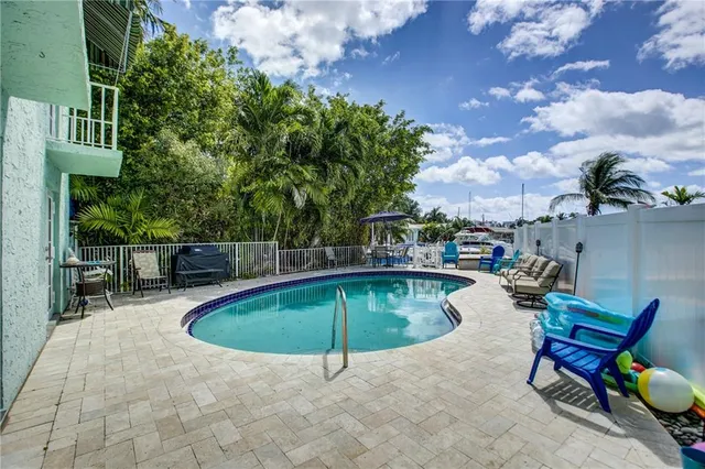 a swimming pool with outdoor seating and yard