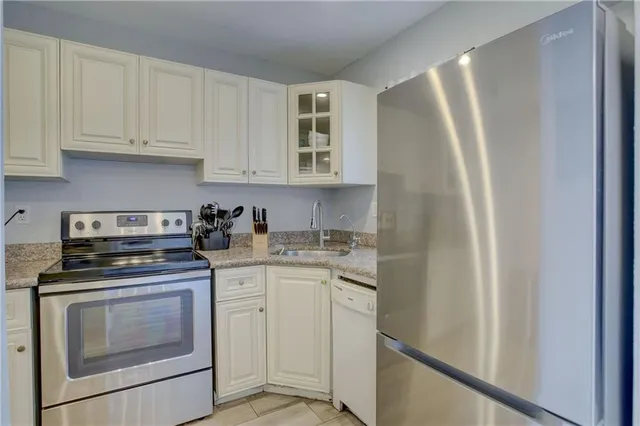 a kitchen with white cabinets and white appliances