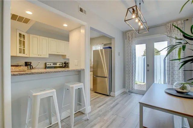 a kitchen with stainless steel appliances granite countertop a refrigerator a stove and a sink