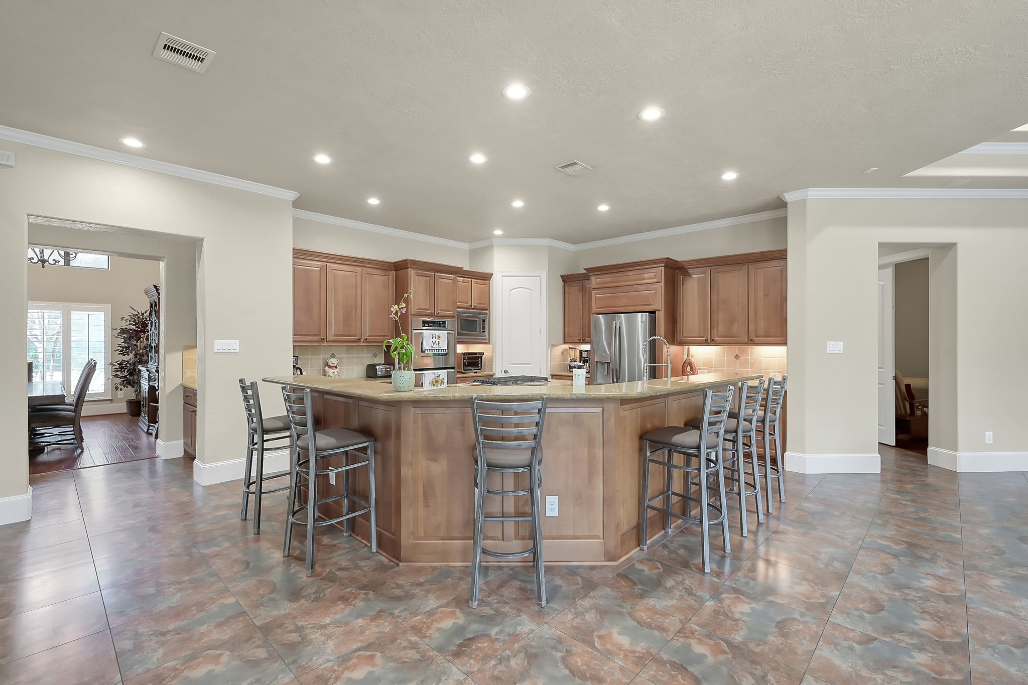 22742 Timberlake Creek Road Tomball, TX 77377 - Photo 17 of 50 a kitchen with kitchen island a dining table chairs and white cabinets