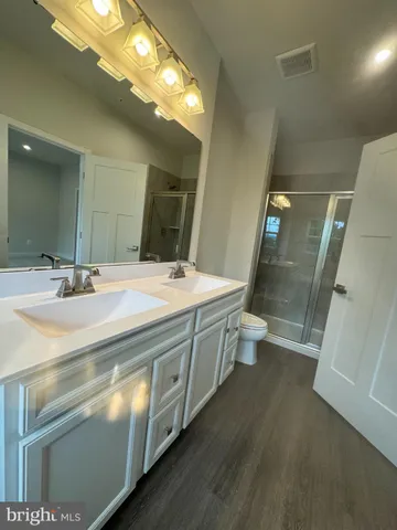 a bathroom with a double vanity sink toilet and shower