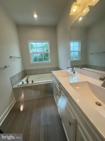 a bathroom with a tub sink and mirror