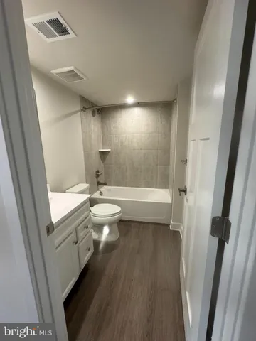 a bathroom with a sink a toilet a tub and shower