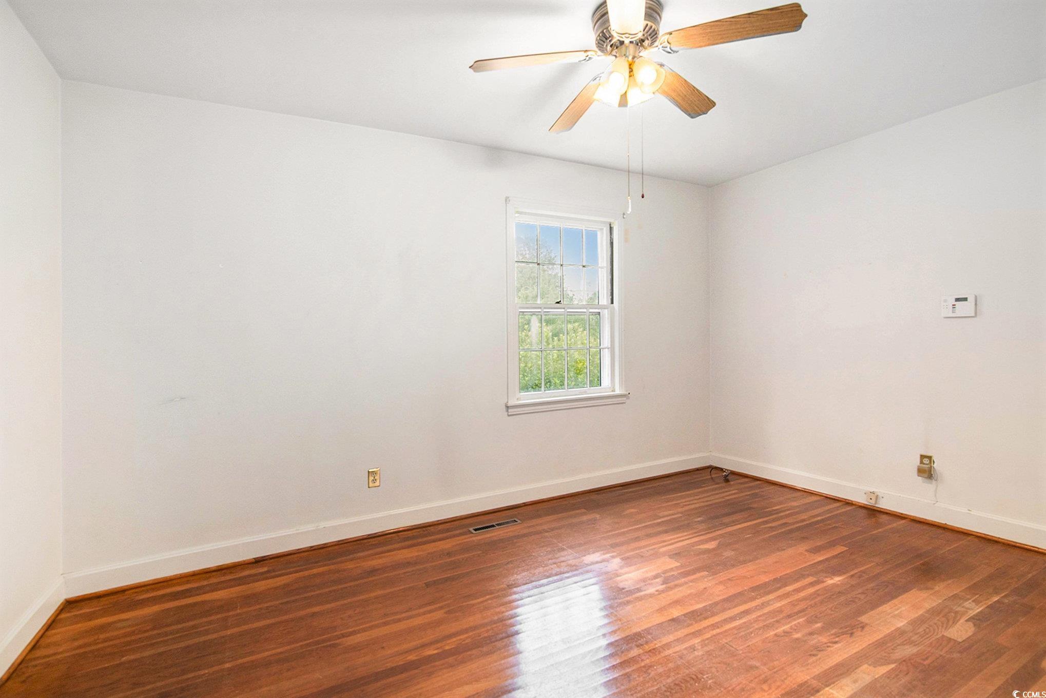 1008 North Main Street Marion, SC 29571 - Photo 14 of 27 Empty room with dark wood finished floors and ceiling fan