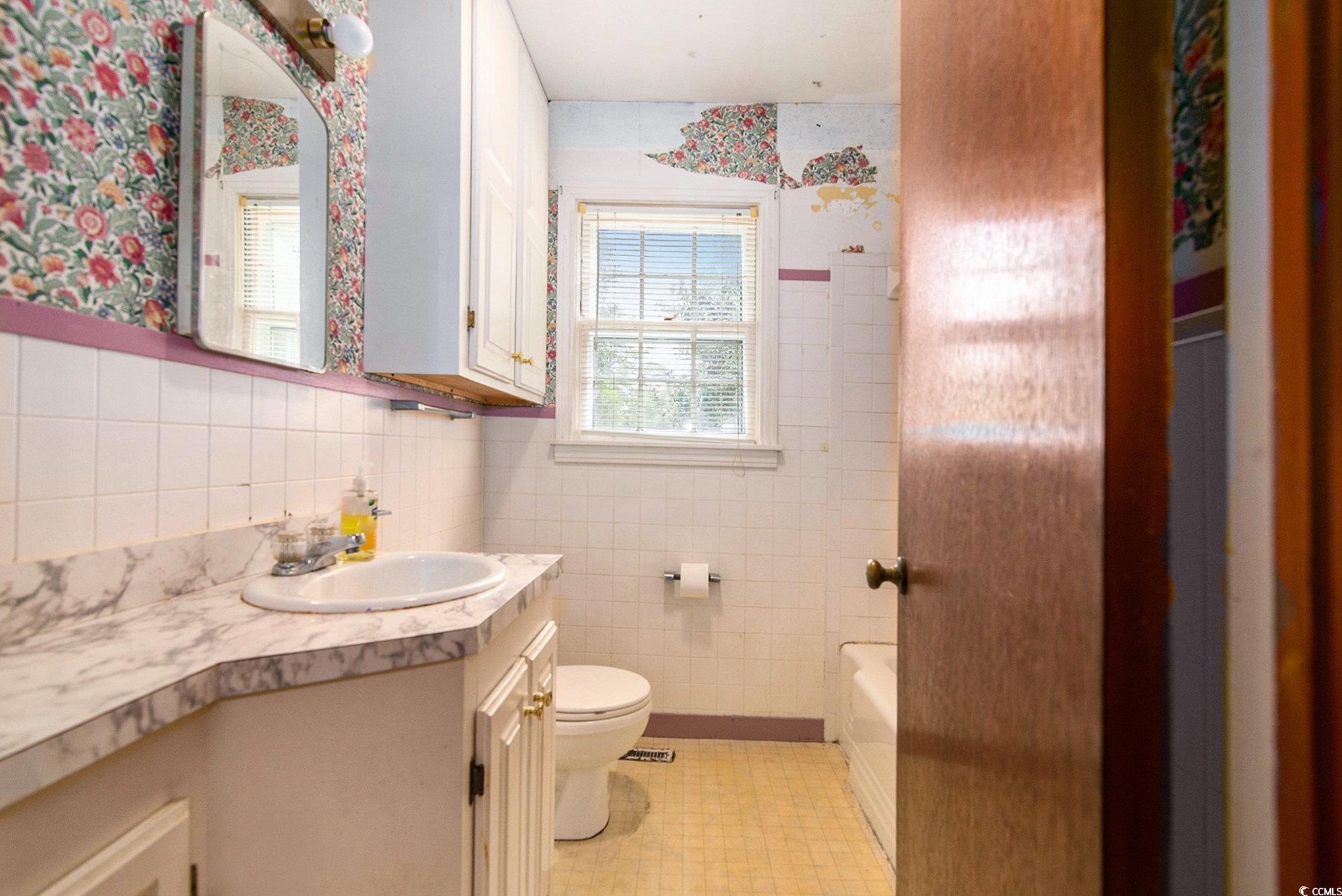 1008 North Main Street Marion, SC 29571 - Photo 20 of 27 Full bath with tile walls, vanity, wallpapered walls, tub / shower combination, and light tile patterned flooring