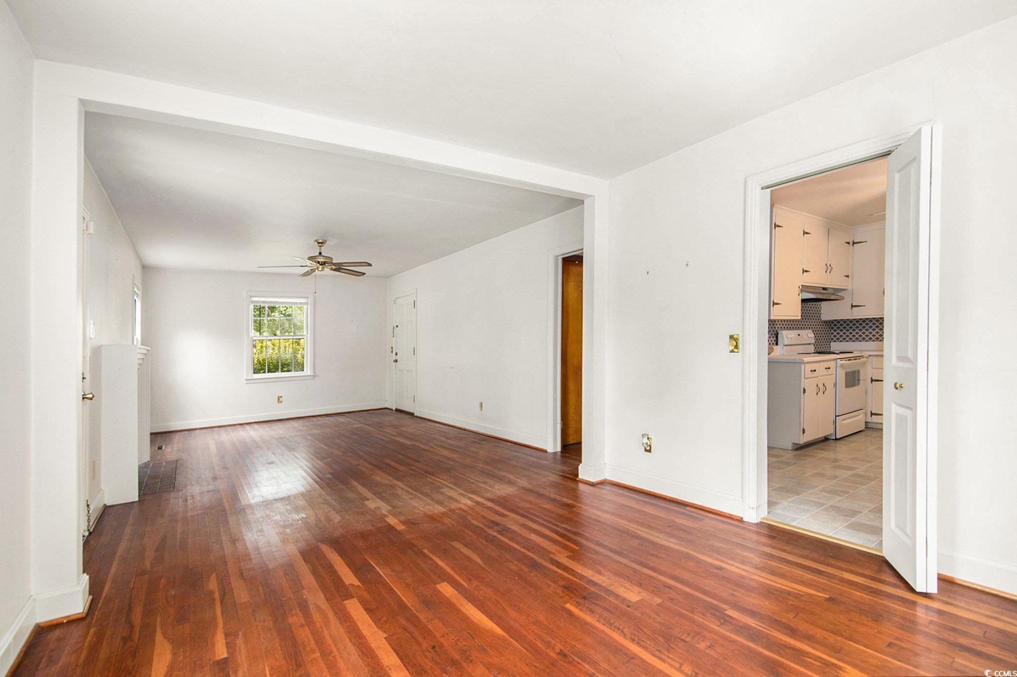 1008 North Main Street Marion, SC 29571 - Photo 7 of 27 Unfurnished living room featuring dark wood-style floors and a ceiling fan