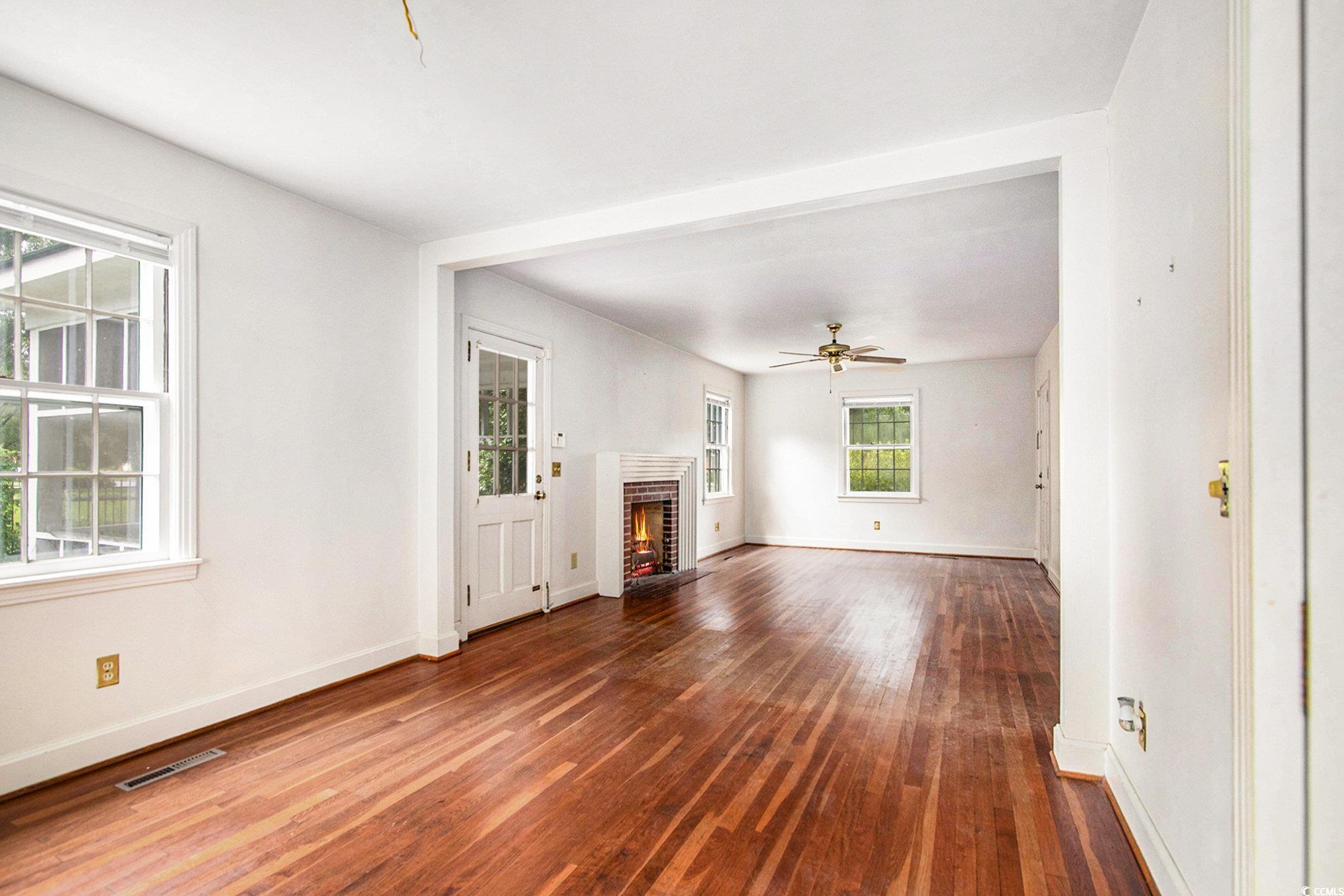 1008 North Main Street Marion, SC 29571 - Photo 9 of 27 Unfurnished living room with dark wood-style floors, a fireplace, and ceiling fan
