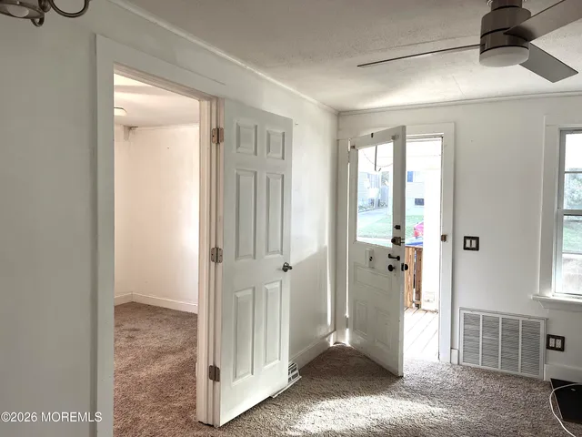 a view of a livingroom with wooden floor and windows