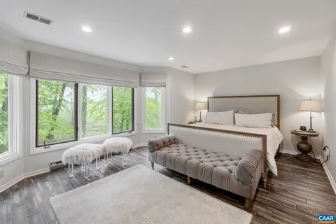 a bedroom with a bed and a large window