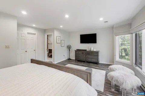 a spacious bedroom with a bed and a flat screen tv