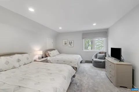 a bedroom with bed tv and window