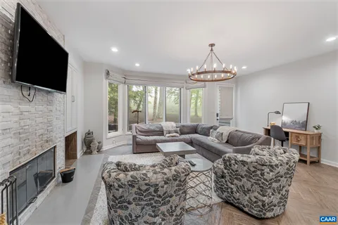 a living room with furniture a flat screen tv and a chandelier